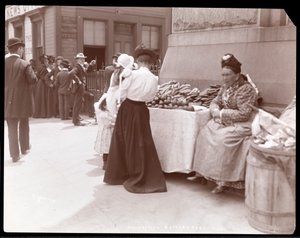 Pohled na obchodníka s ovocem v Battery Parku, pravděpodobně čekajícího na imigranty z Ellis Island, New York, kolem roku 1901 (stříbrný želatinový tisk)